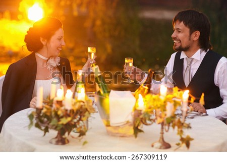 rich stylish happy bride and groom drink champagne at the  wedding table decorated with flowers peonies and candles Rome Italy