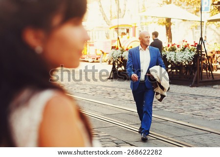 bald groom and bride brunette walking on the streets of the old city by tram tracks Lviv Ukraine