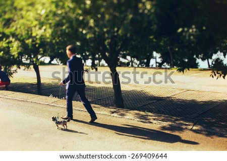 stylish good groom walking with dog on street of Montenegro