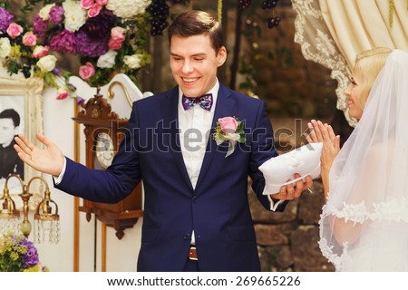 wonderful stylish rich happy bride and groom smiling at a wedding ceremony in  garden near arch with flowers Montenegro