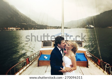 Stylish young bride and groom huging and smiling on board the yacht Montenegro on board the yacht Montenegro