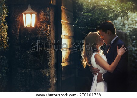 in love cute bride and groom look at each other in the midst of green leaves light falls Montenegro