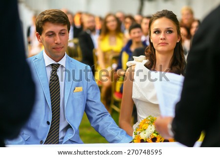 rich stylish groom and bride  holding hand near the arch of sunflowers wedding ceremony