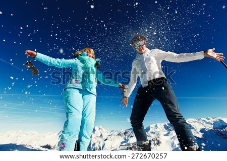 woman and man in ski suit jump on the background of the Alps Courchevel
