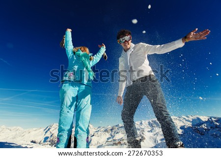woman and man in ski suit jump on the background of the Alps Courchevel