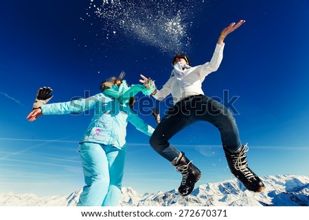 girl and boy in ski suit jump on the background of the Alps Courchevel