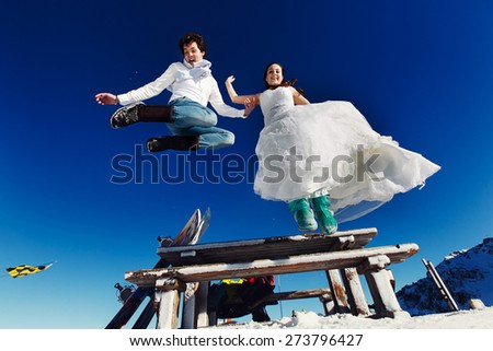 bride and groom in love jump from table on the background of the Alps Courchevel