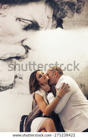 the groom kisses the bride smiling on the background image of ancient man