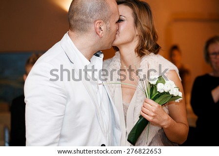 Happy smiling stylish rich bride and groom kissing getting married wedding ceremony