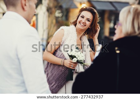 Portrait of happy joyful stylish bride with a bouquet of flowers roses in hand with bracelets and ring