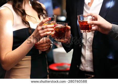 three friends drinking whiskey on  party in club