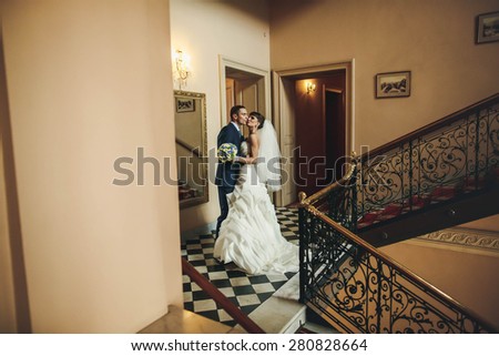 groom and bride hugging and kissing on the  background corridor