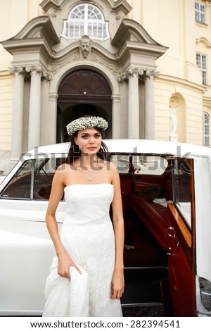 happy elegant cute stylish bride in crown on the background car and opera house