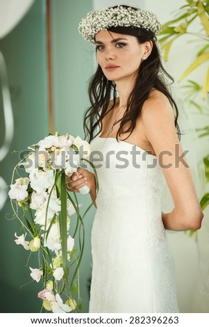elegant stylish bride with bouquet of orchids on the background restaurant