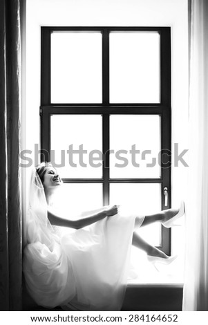 stylish luxury gorgeous blonde bride posing on the background hotel room