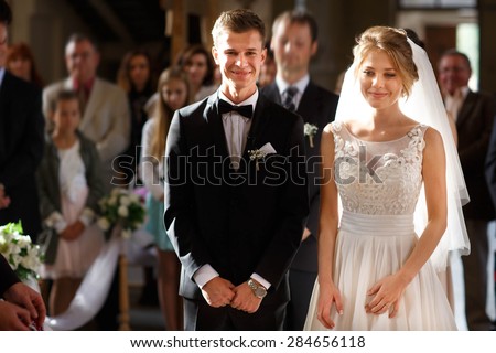 classic wedding ceremony of stylish young luxury bride and groom in the ancient old church
