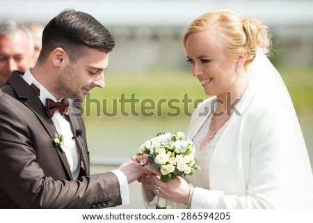 gentle romantic happy couple exchanging wedding rings on the background of spring nature