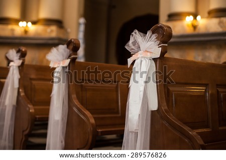 wedding decoration with ribbons and flower in the church for ceremony