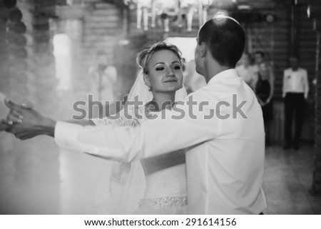 first dance of the young blonde happy bride and groom against the background wooden restaurant