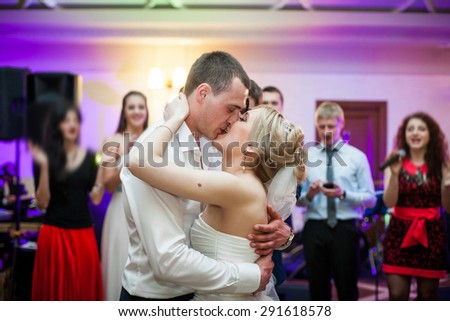 happy elegant married couple dancing and kissing in a restaurant, celebrating wedding