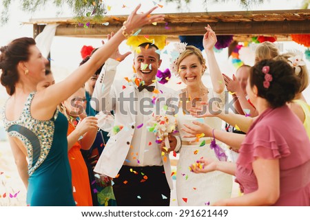 beautiful  gorgeous blonde bride  and stylish groom under confetti, hawai  colorful sand ceremony  on cyprus