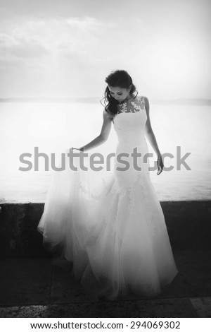 beautiful gorgeous young gentle bride with curly hair, on the background landscape of sea