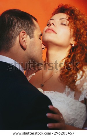 grom huging kissing bride with red hair outdoors Lviv