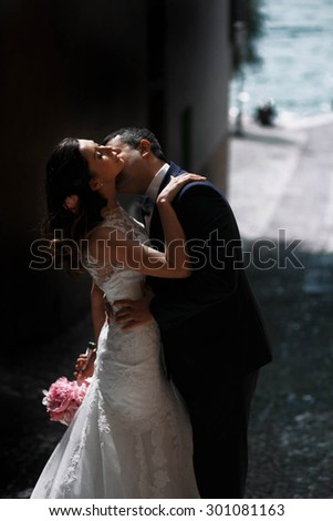 sweet romantic beautiful happy couple kissing at stone streets of the ancient city, mediterranean sea, mountains