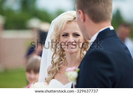 stylish elegant beautiful bride and groom looking at each other at the wedding ceremony