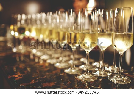 A lot of wine glasses with a cool delicious champagne or white wine at the bar. Alcohol background.