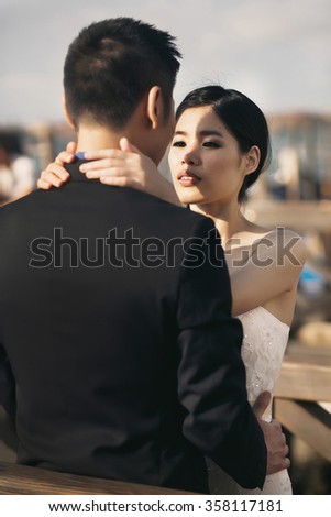 Beautiful stylish Asians bride and groom walking on the summer streets of Venice, Italy