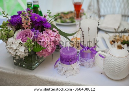 Beautiful wedding reception table arrangement, tableware and white and purple flowers