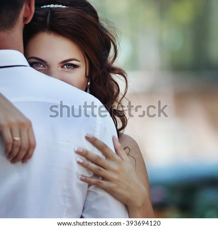 Beautiful sensual bride hugging handsome groom closeup
