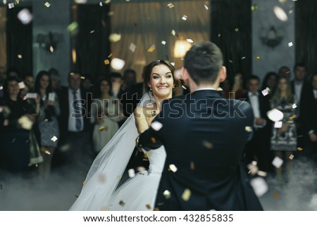 Bride smiles while dancing in the rain of confetti