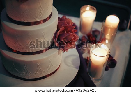 Delicious beautiful white wedding cake with purple flowers & candles