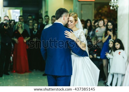 People admire a stylish wedding couple during their firs dance