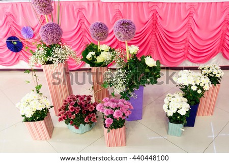 White, pink and violet bouquets stand in striped vases