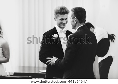 Man greets a young groom in classic tuxedo