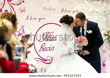 The brides kissing  near wedding banner