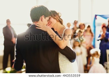 Sun shines over happy just married couple while they dance at the first time