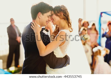 Bride leans to a groom during a dance outside under the bridght sun