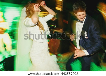 Cool newlyweds dance in green disco lights