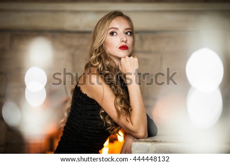 The charming girl sits on the chair