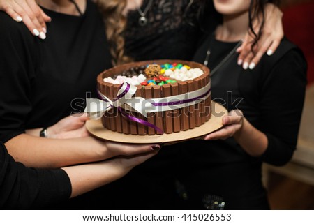 The friends presents a cake on the birthday party