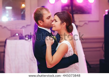 Stunning wedding couple dance at their first time in hall fool of pink light