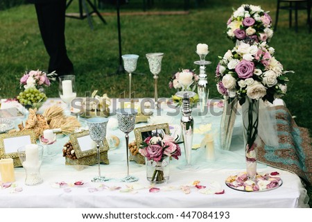 White and violet bouquets stand on the table with silver candleholders