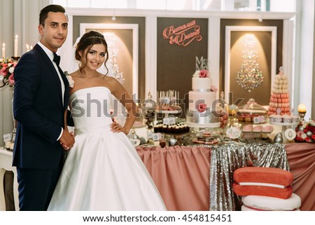 Beautiful couple and wedding table with sweets