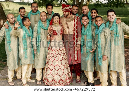 Groomsmen dressed in green sherwani surroung magnificent Indian wedding couple