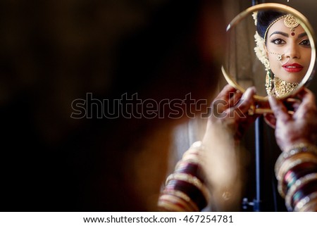 Reflection of dreamy Indian bride with seductive red lips