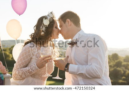 A moment before a kiss between wedding couple enjoying wine on the roof